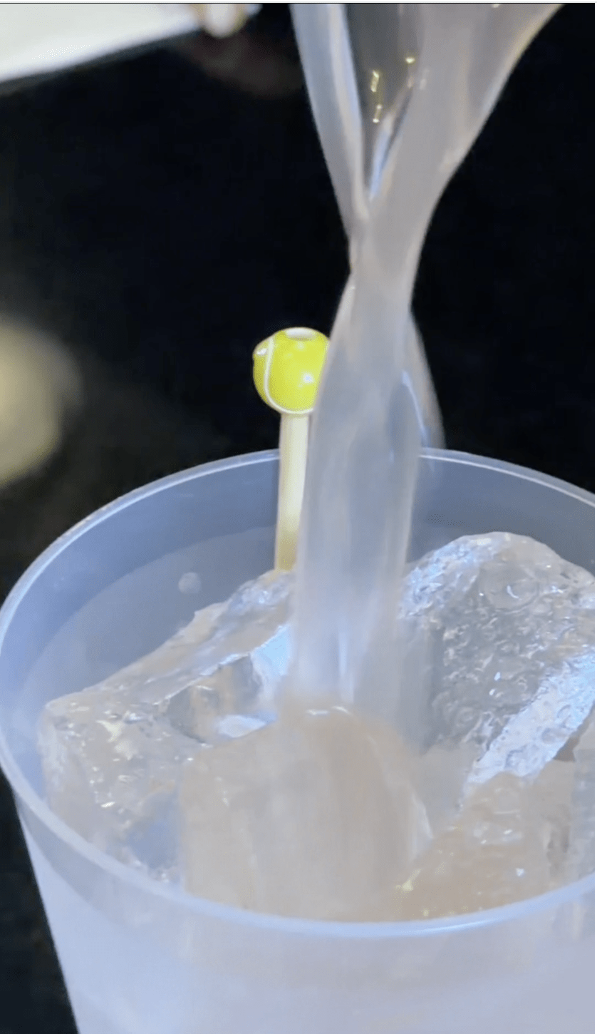 A cocktail being poured into a cup
